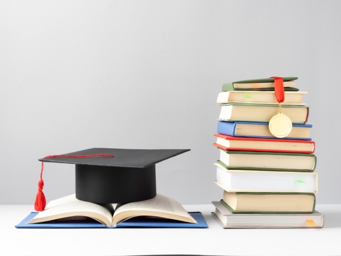Strumenti simbolici di un percorso di studi: il cappello da laureato, i libri di conoscenza e la medaglia del riconoscimento Strumenti simbolici di un percorso di studi: il cappello da laureato, i libri di conoscenza e la medaglia del riconoscimento